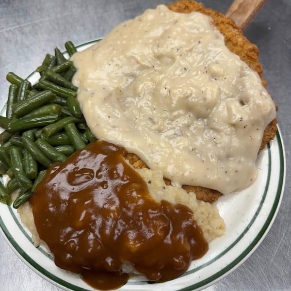 Ash's Irish Pub's chicken fried steak with white gravy, mashed potatoes with brown gravy, and green beans.