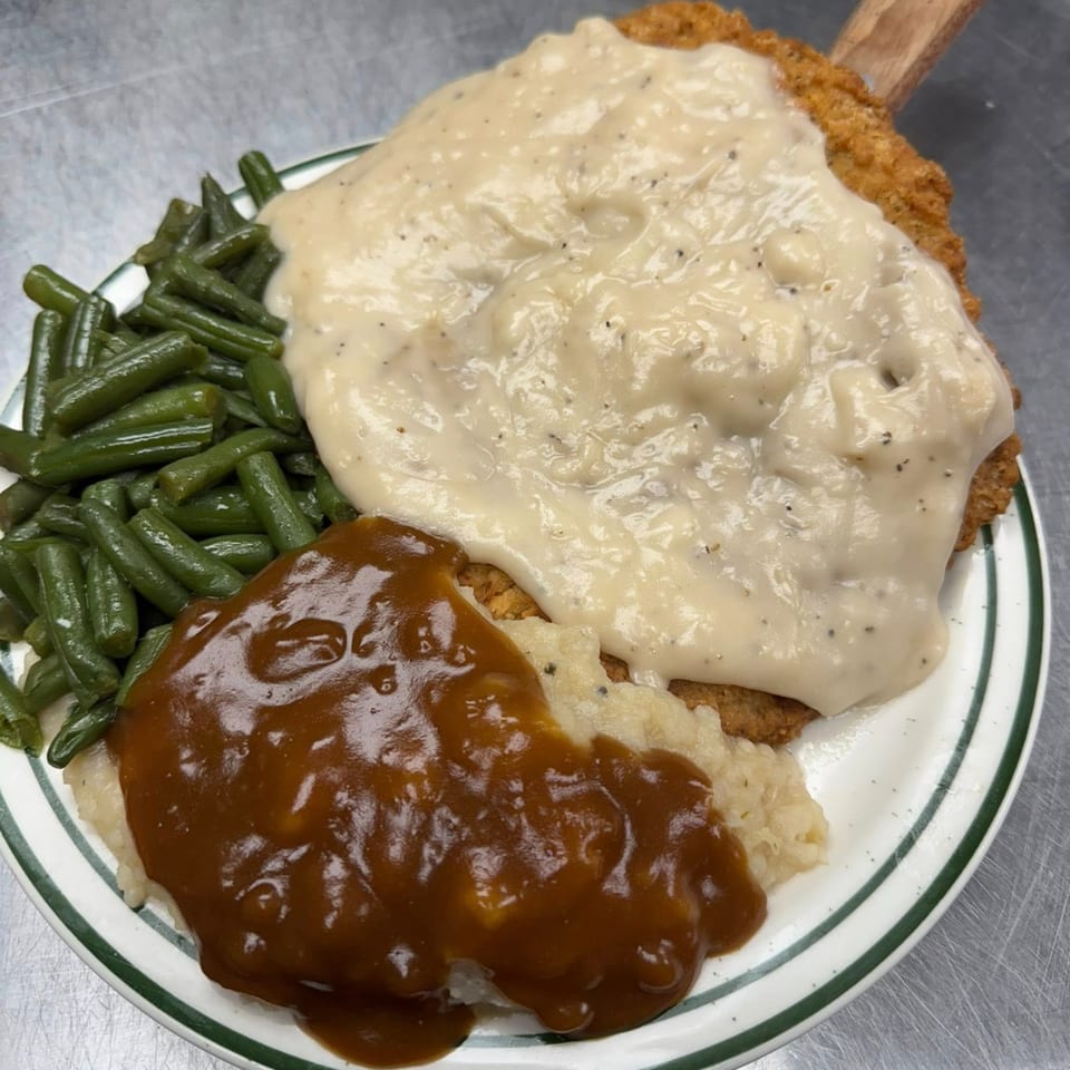 Ash's Irish Pub's chicken fried steak with white gravy, mashed potatoes with brown gravy, and green beans.